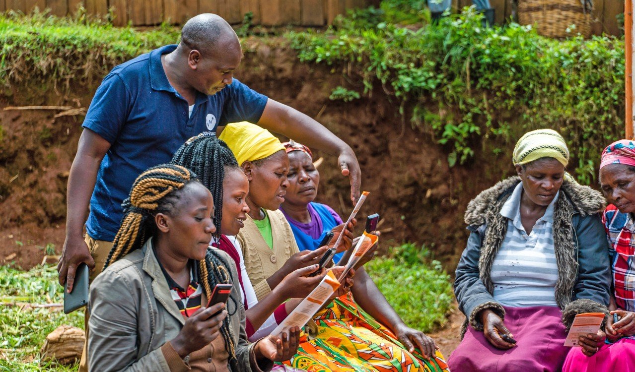 Bildet er tatt i Nairobi, Kenya. Ein mann instruerer kvinner i korleis dei kjøper seg rimeleg mikroforsikring.