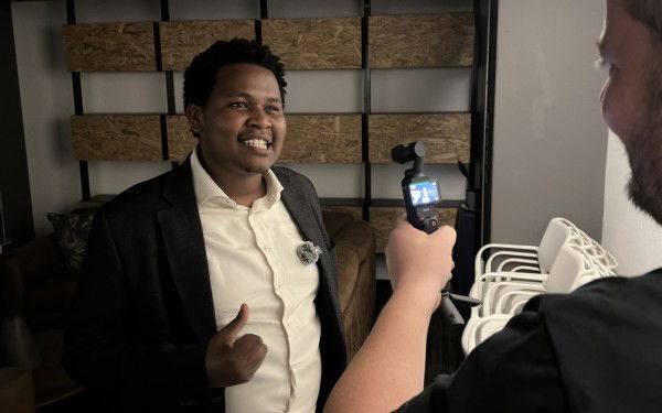 David Mburu, a 31 year old man, looks into a camera held by Roger Sevrin Bruland.